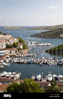 Elevated view down the long, narrow entrance to Port d'Addaia with pontoons and islets on Menorca's north coast